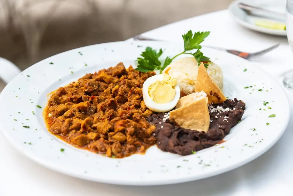 Queso relleno — whole Edam cheese ball stuffed with spiced meat served with kol sauce in Yucatan