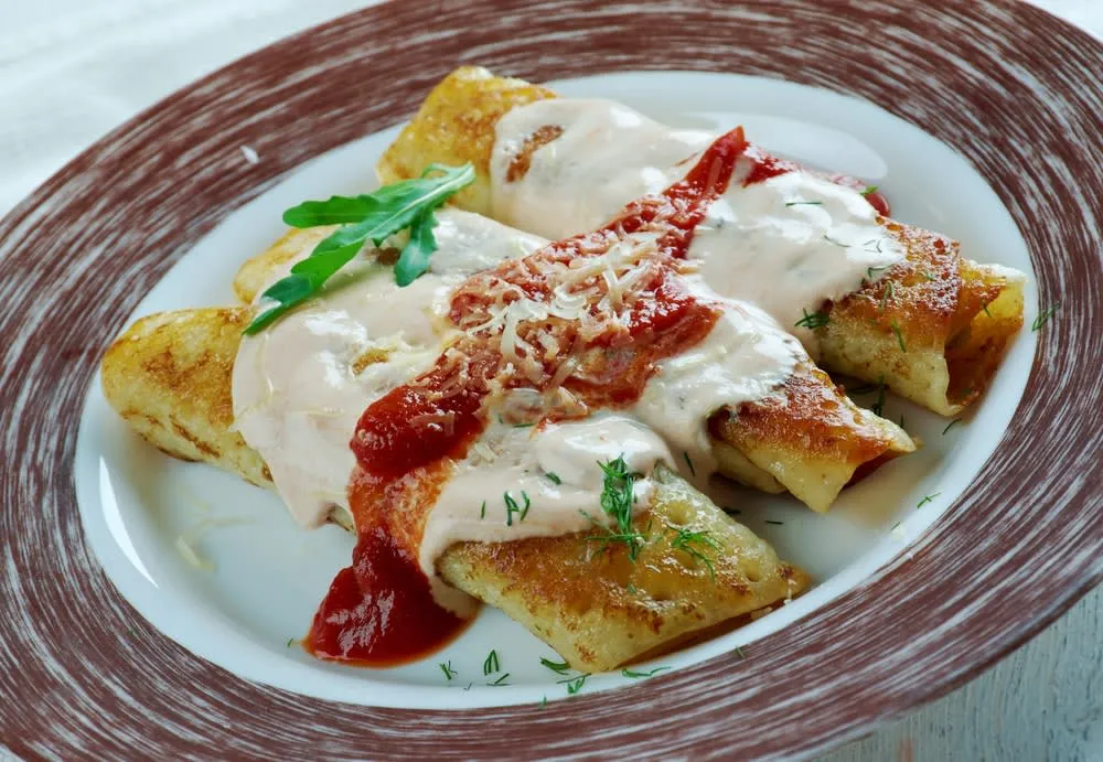 Papadzules — rolled corn tortillas in pumpkin seed sauce topped with tomato-habanero salsa and hard boiled egg