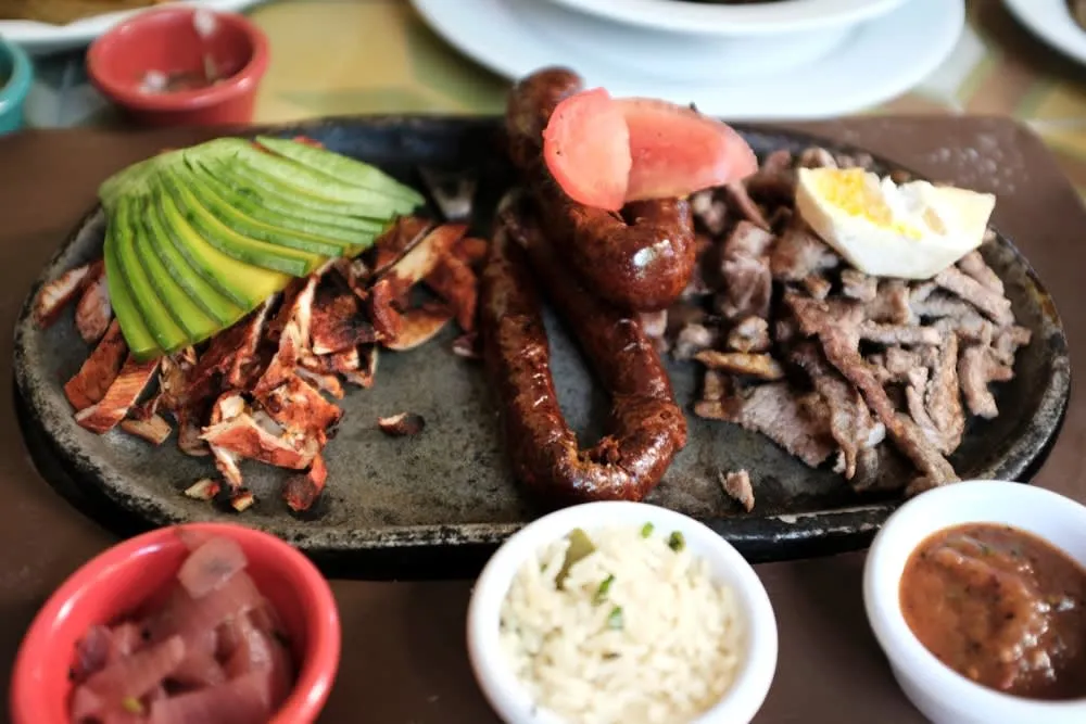 Longaniza de Valladolid — dark red anise-seasoned sausage served with eggs and black beans at a Yucatan market