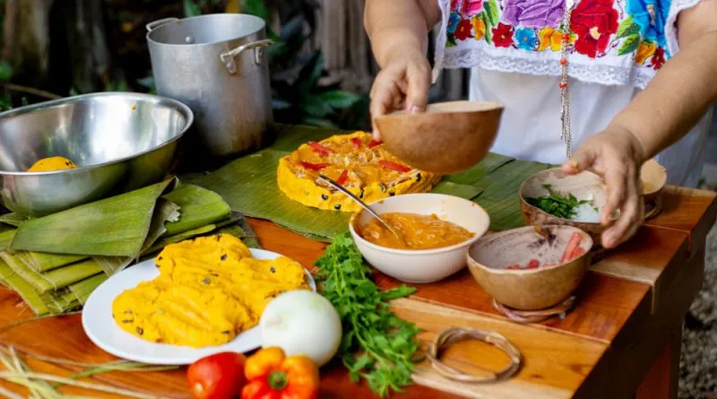 Traditional Yucatan food spread including cochinita pibil tacos and papadzules on a colorful Mérida table