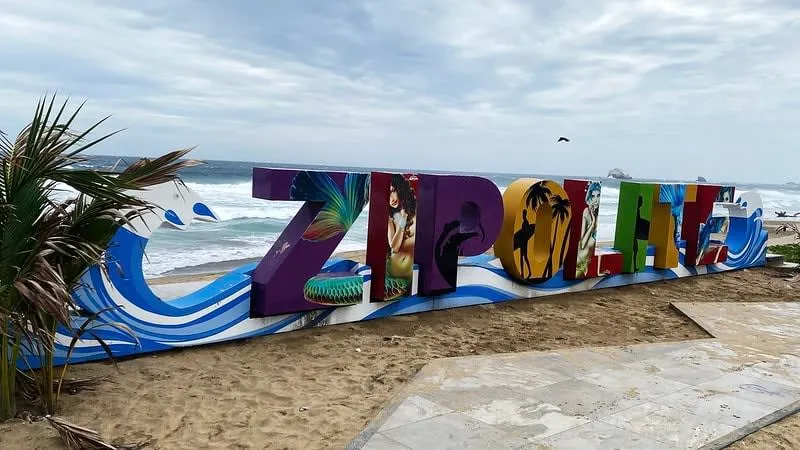 Wide Zipolite beach with Pacific surf during humid August weather