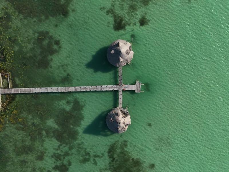 Wooden dock extending into the crystal-clear turquoise waters of Bacalar Lagoon