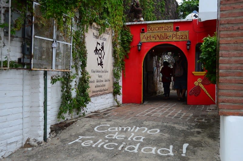 Open-air art market with colorful paintings and hanging lights