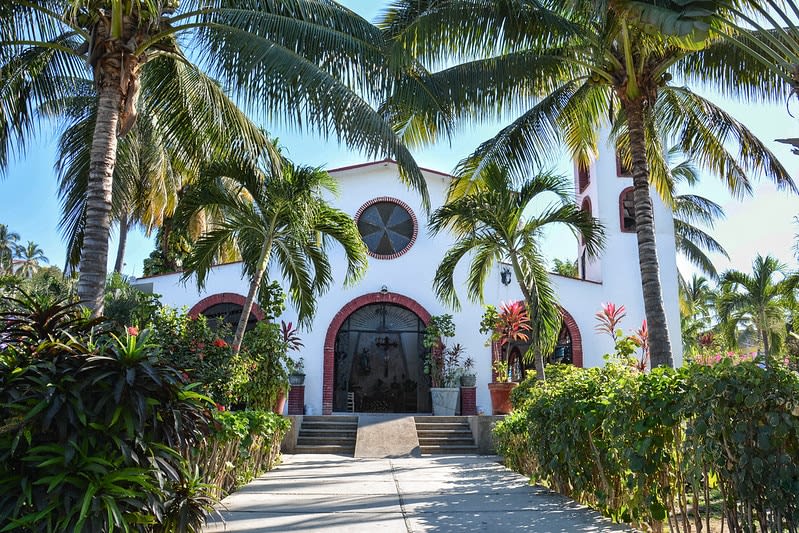 White church with a bell tower behind a town square