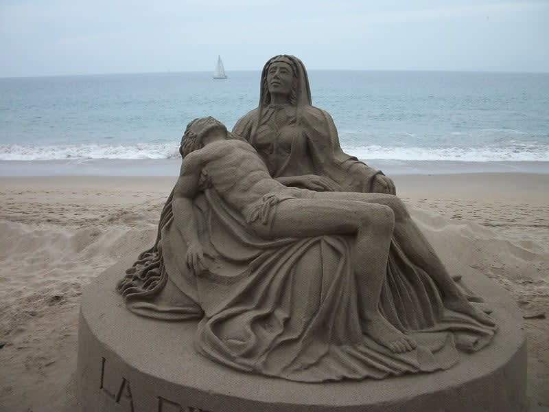 Large sand sculpture on the beach with the ocean behind