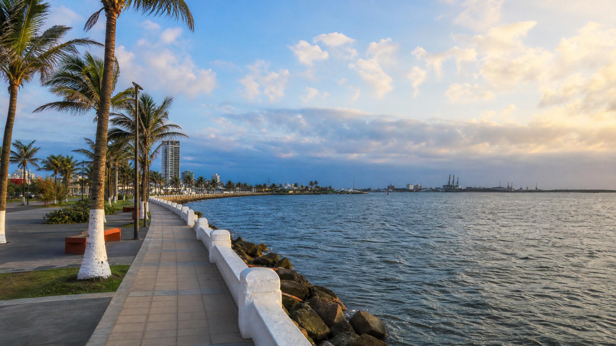 Coatzacoalcos malecon in January with Gulf water, palms, dry-season light, and soft clouds