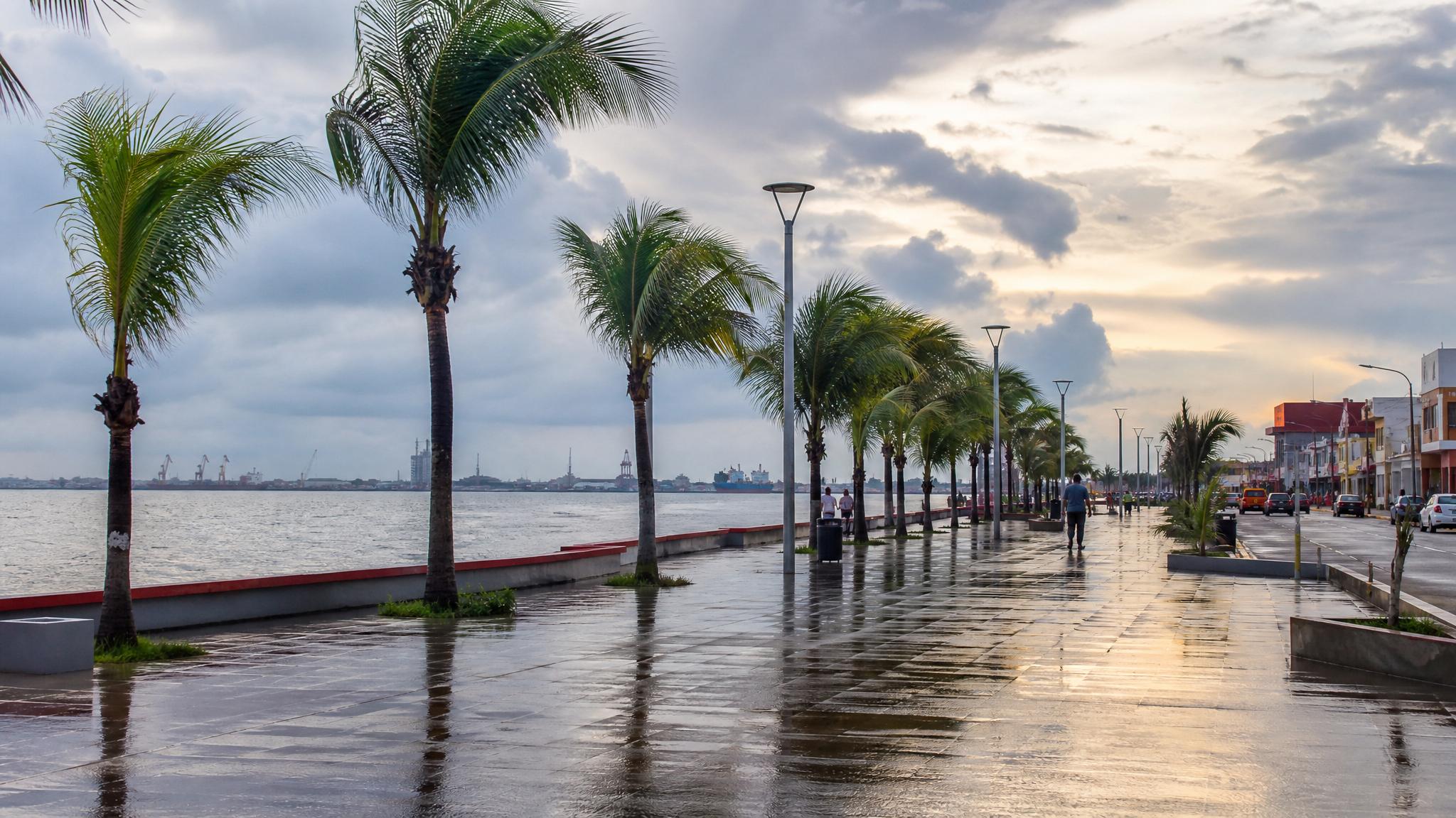 Coatzacoalcos waterfront after a June rain shower with Gulf clouds, palms, and wet pavement