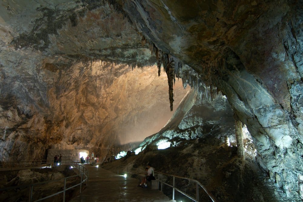 Enormous illuminated cave chamber in Grutas de Cacahuamilpa with massive stalactite columns and vaulted limestone ceiling
