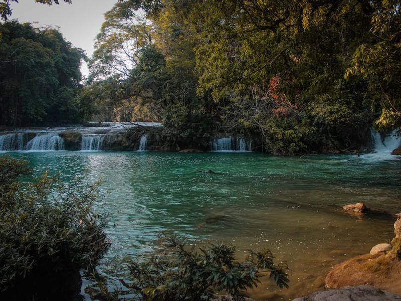 Powerful waterfall with kayakers paddling on turquoise river in Huasteca Potosina