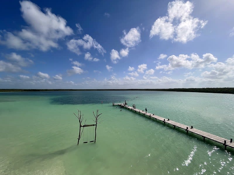 Wooden dock and shallow turquoise water at Kaan Luum Lagoon