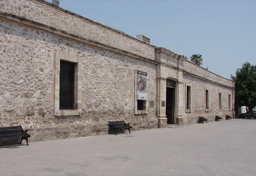 Shaded plaza and low-rise buildings in Monclova city center during July