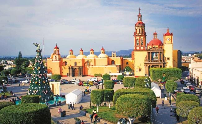 Colonial stone bridge and river in San Juan del Río, Querétaro with historic buildings on the riverbank