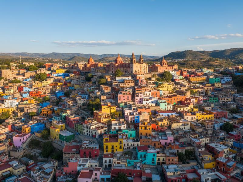 Colorful colonial houses of Guanajuato stacking up hillside in vibrant yellows, oranges, and pinks